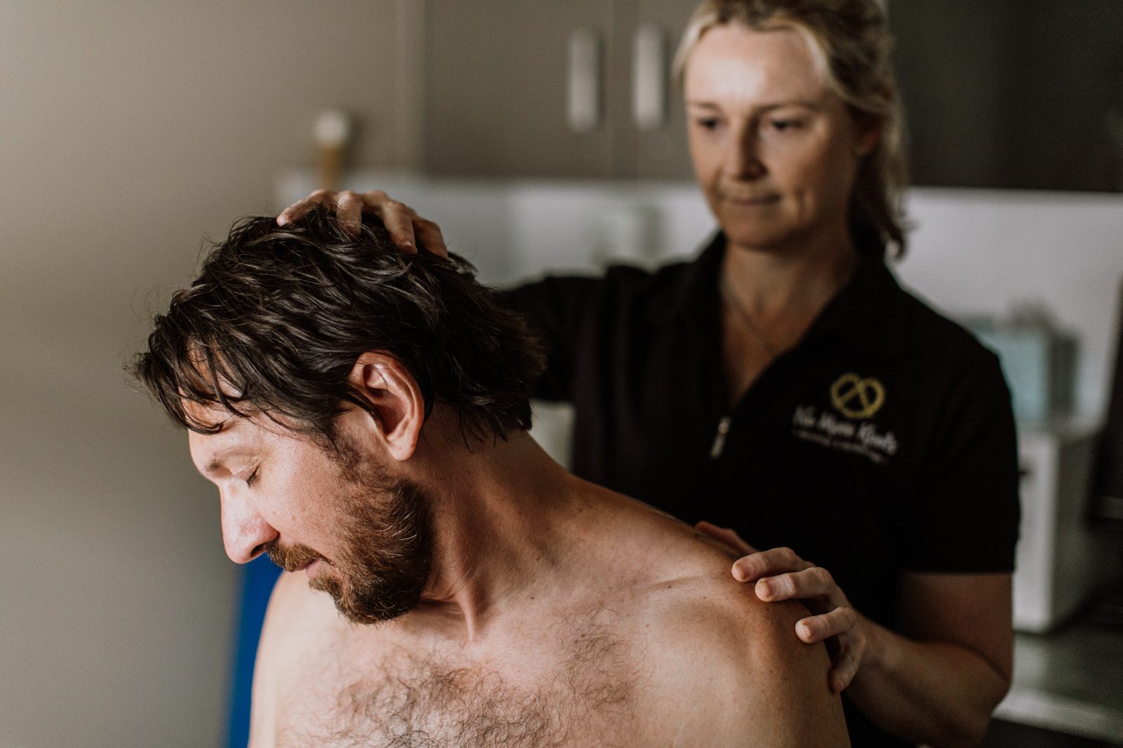A No More Knots therapist working on a client's neck and shoulder